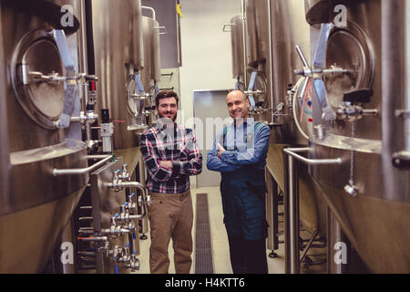 Confiant et travailleur permanent propriétaire au milieu de la machinerie Banque D'Images