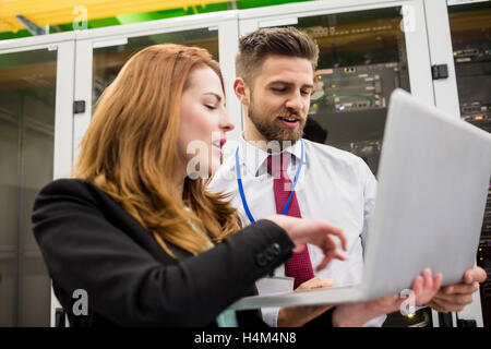 Techniciens discussing over laptop Banque D'Images