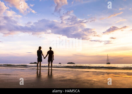 Silhouette d'heureux couple ayant une romantique promenade côtière et à la mer à Paradise Island Banque D'Images