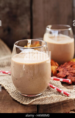 Pumpkin smoothies contre un fond rustique. Profondeur de champ avec l'accent sur le dessert en premier plan. Banque D'Images