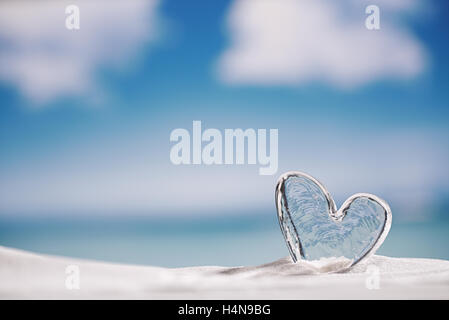 Coeur de verre clair sur une plage de sable blanc, océan, ciel et seascape Banque D'Images