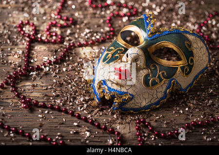 Masque de carnaval avec collier rouge sur fond de bois Banque D'Images