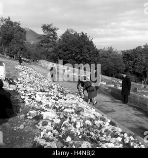 Photo de fichier en date du 29/10/1966 de la reine Elizabeth II et le duc d'Édimbourg rendre hommage avec des fleurs aux gens tués dans le village d'Aberfan après un effondrement catastrophique de la mine d'un butin-tip. La catastrophe a causé la mort de 144 personnes, dont 116 enfants. Banque D'Images