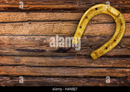 Golden Horseshoes sur vintage wooden board Banque D'Images