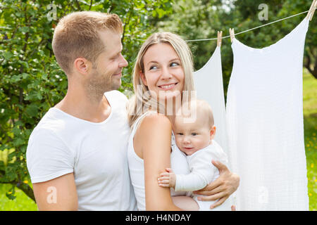 Heureux jeune famille avec un mignon bébé à l'extérieur Banque D'Images