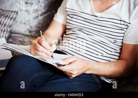 Un homme assis à l'aide d'un stylo et de dessin croquis, un concepteur au travail. Banque D'Images