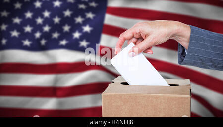 Image composite de close-up of businesswoman putting bulletin de vote fort Banque D'Images