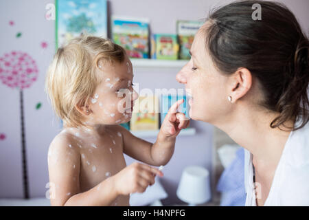 Petite fille avec la varicelle, crème antiseptique appliqué aux ar Banque D'Images