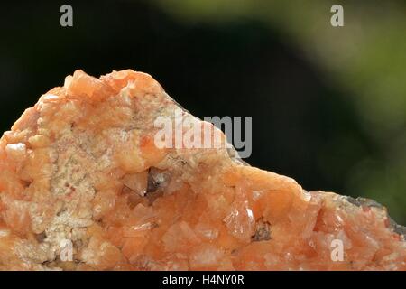 Minéraux pierre quartz Orange en détail avec un fond vert Banque D'Images