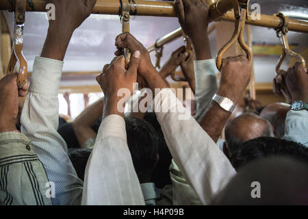 L'Inde,Indian,train,Asie,rail,transport,ferroviaire,Strap pendaison banlieusards,passagers, sur réseau express régional à la maison du travail le train. Mumbai, Bombay, Banque D'Images