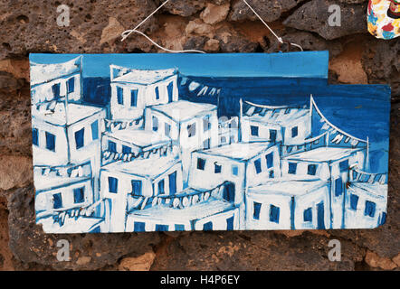 El Cotillo, Fuerteventura, Îles Canaries, Afrique du Nord, Espagne : Fait main décorations, un panneau de bois blanc avec des maisons suspendues sur des rochers noirs Banque D'Images