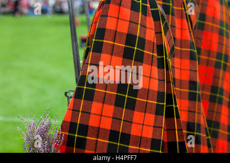 Les fiers marcheurs de la Lonach Highlanders, portant manteau plaid tartan rouge Wallace assistant à la Scottish Highland Games à Donside, Ecosse, Royaume-Uni Banque D'Images