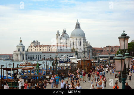 Vue depuis le bord de la Riva degli Schiavoni auprès des touristes dans la Basilique Santa Maria della Salute de Venise en Italie. Banque D'Images