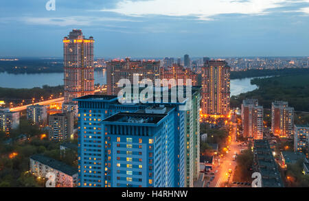 La vue de la hauteur sur l'immeuble de grande hauteur à la périphérie de Moscou, dans le crépuscule sur le fond de la rivière Banque D'Images