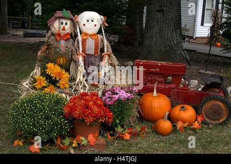 Décoration automne en plein air avec des épouvantails, mamans, tracteur, et les citrouilles Banque D'Images