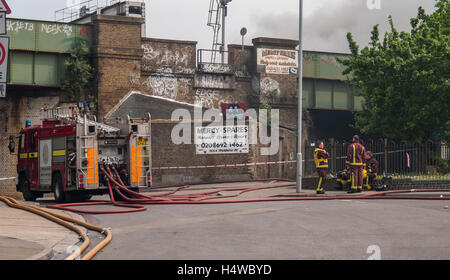 Les pompiers de Londres tolérer que leur pompe fournit de l'eau à une pompe 10 incendie dans une casse. Banque D'Images