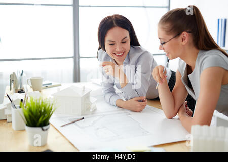 Brainstorming des femmes tout en regardant un dessin de construction Banque D'Images