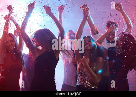 Amis extatique la danse de la pluie de confettis Banque D'Images