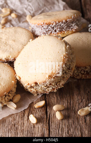 De délicieux cookies argentin alfajores avec de la crème sur le papier sur la table verticale. Banque D'Images