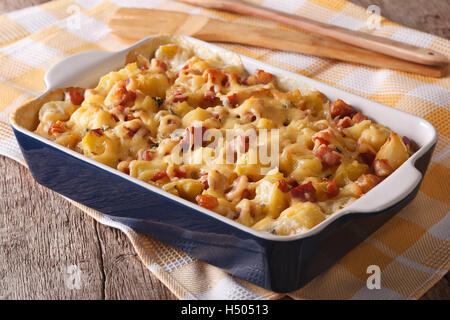Français maison pommes de terre au four avec du bacon et fromage close up dans le plat de cuisson horizontale. Banque D'Images