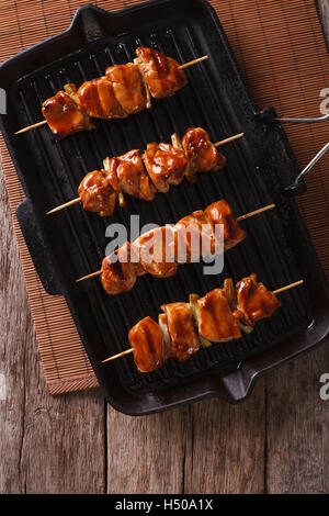 Brochettes de poulet yakitori japonais sur un gril vertical Vue de dessus. Banque D'Images