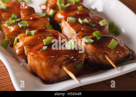 Barbecue japonais : poulet yakitori macro sur une assiette sur la table horizontale. Banque D'Images