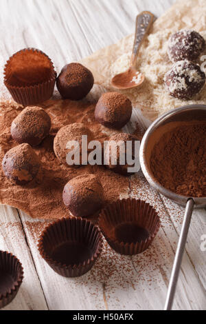 Truffes au chocolat, saupoudrer de poudre de cacao et les noix sur la table verticale. Banque D'Images