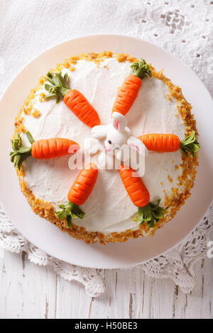 Beau gâteau aux carottes avec candy bunny close-up sur la table verticale Vue de dessus. Banque D'Images