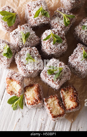 Gâteau Lamington avec noix de coco sur la table. vertical, style rustique Banque D'Images