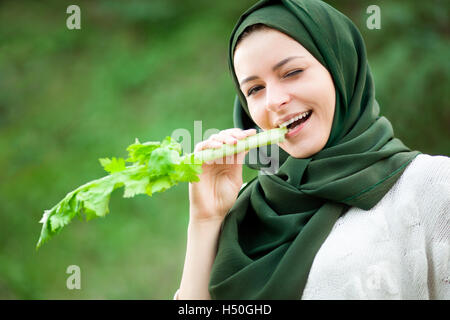 Vegan musulmane Femme avec voile de manger un céleri Banque D'Images