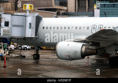 Un avion connecté à une passerelle sur laquelle vous travaillez dans un aéroport avant son prochain vol prévu. Banque D'Images