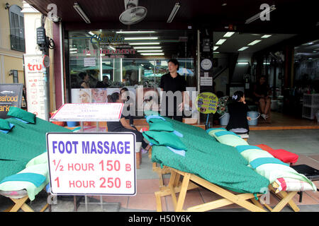 Bangkok, Thaïlande. 18 Oct 2016. Massage des pieds Les travailleurs dans des vêtements noirs en attente de client dans leur boutique à Khao San road à Bangkok, Thaïlande. Le roi Bhumibol Adulyadej de Thaïlande est décédé après une longue maladie, le palais a annoncé le 13 octobre 2016. Un Sahakorn Crédit : Piti/Alamy Live News Banque D'Images