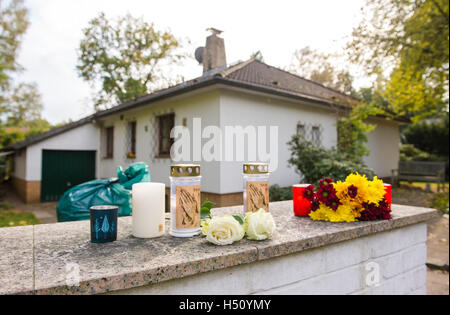 Des fleurs et des bougies sur un mur extérieur d'une maison unifamiliale à Wedel, Allemagne du nord, 18 octobre 2016. Les corps des deux enfants ont été découverts dans la chambre il y a deux jours. A midi aujourd'hui, la police a découvert les corps d'une femme. Photo : Daniel Bockwoldt/dpa Banque D'Images