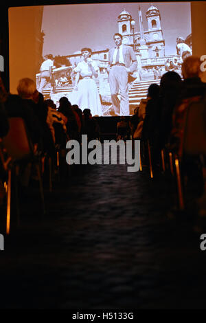 Rome. 18 Oct, 2016. Les gens regardent le film de Rome avec Gregory Peck et Audrey Hepburn à Place d'Espagne le 18 octobre 2016 à Rome, Italie. Le célèbre film de Rome avec Gregory Peck et Audrey Hepburn a été éliminée mardi à Place d'Espagne de Rome pour célébrer le centenaire de la naissance de Gregory Peck. © Jin Yu/Xinhua/Alamy Live News Banque D'Images