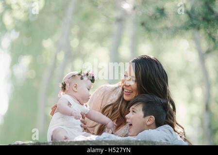 Portrait of a smiling mother, garçon et fille avec une couronne de fleurs sur sa tête. Banque D'Images
