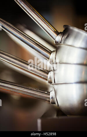 Gros plan d'une pile de pots en acier inoxydable dans une cuisine de restaurant. Banque D'Images