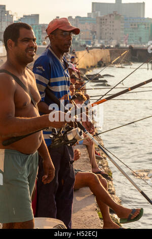 Les gens pêchent le long de la digue de Malecón dans le centre de La Havane, Cuba. Banque D'Images