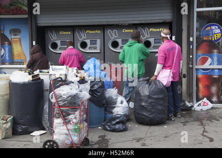 Les gens dans des boîtes, des bouteilles de plastique et de verre qu'ils ont ramassé des déchets mis dans les rues de Brooklyn, New York. Banque D'Images