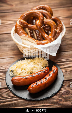 Bretzels, saucisses et choucroute sur table en bois Banque D'Images