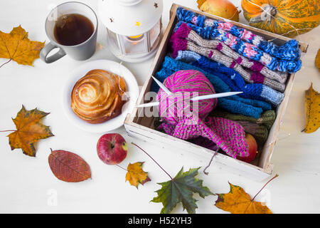 Laine à tricoter et des aiguilles avec lanterne à bougie, séché les feuilles d'automne,pommes,tea cup Banque D'Images