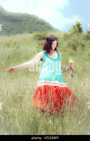 Hippie girl picking flowers dans le pré Banque D'Images