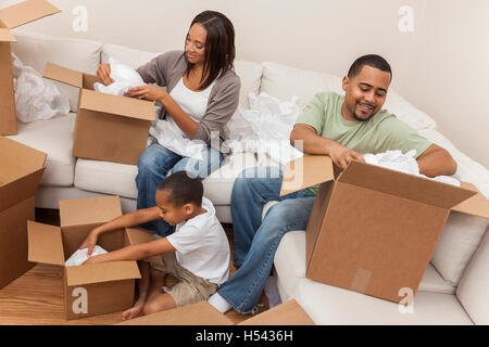 African American Family, parents et fils, adulte et enfant, déballage des boîtes et de déménager dans une nouvelle maison. Banque D'Images