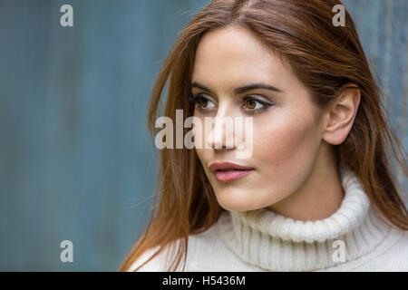 Portrait d'une belle jeune fille ou jeune femme aux cheveux rouges portant un cavalier blanc Banque D'Images