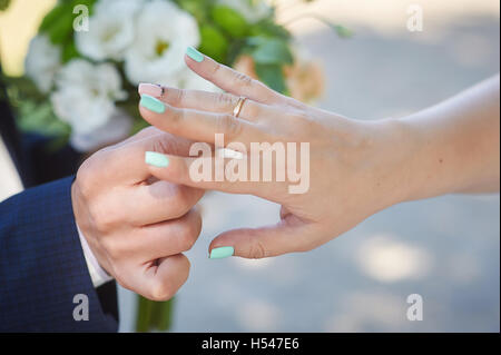 Le marié porte un anneau de mariage mariée sur le doigt Banque D'Images