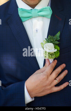 Boutonnière pour le marié ajuste sa main dans une poche de veste Banque D'Images