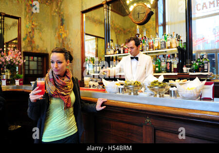 Une jeune femme est en sirotant un cocktail Campari à l'intérieur de l'Camparino cafe, dans la Galleria Vittorio Emanuele II à Milan, Italie Banque D'Images