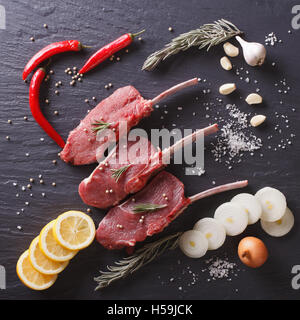 Steaks de boeuf avec des ingrédients sur une table en pierre noire libre. contexte Vue d'en haut Banque D'Images