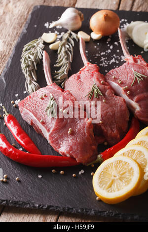 Steaks de boeuf avec des ingrédients sur un tableau noir ardoise libre. La verticale Banque D'Images