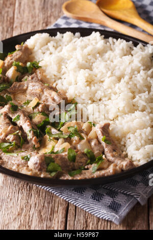 Bœuf stroganoff garnie avec du riz sur une plaque sur la table. La verticale Banque D'Images