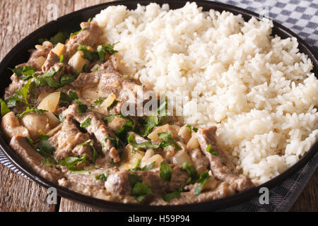 Bœuf stroganoff aux champignons et riz close-up sur une plaque sur la table horizontale. Banque D'Images